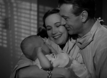 Movie still from “Casanova Brown” (1944), directed by Sam Wood – A man and a woman are holding a baby; Close Up shot, High angle