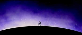 A person standing on top of a hill at night