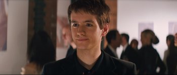 A young man in a black jacket and a red tie
