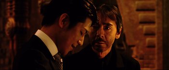 Movie still from “Casshern” (2004), directed by Kazuaki Kiriya – A man and a man wearing a suit and tie; Close Up shot, Low angle