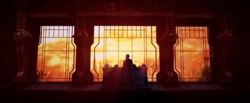 Movie still from “Casshern” (2004), directed by Kazuaki Kiriya – A man sitting at a desk in front of a large window; Extreme Wide shot, Low angle