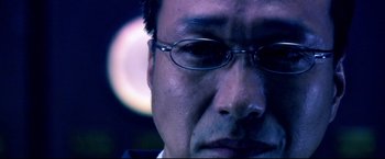 Movie still from “Casshern” (2004), directed by Kazuaki Kiriya – A man's face wearing glasses; Extreme Close Up shot, Low angle