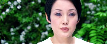 Movie still from “Casshern” (2004), directed by Kazuaki Kiriya – A person with short black hair; Close Up shot, Over the shoulder angle