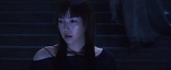Movie still from “Casshern” (2004), directed by Kazuaki Kiriya – A young woman with long black hair wearing a black shirt; Close Up shot, Low angle