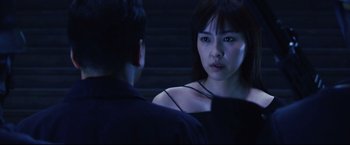 Movie still from “Casshern” (2004), directed by Kazuaki Kiriya – A woman standing next to a man in a dark room; Close Up shot, Over the shoulder angle