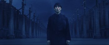 Movie still from “Casshern” (2004), directed by Kazuaki Kiriya – A man standing in front of a row of trees; Medium shot, Low angle