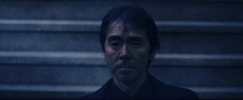 Movie still from “Casshern” (2004), directed by Kazuaki Kiriya – A person wearing a black shirt; Close Up shot, Low angle