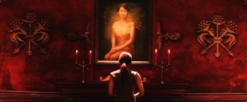 Movie still from “Casshern” (2004), directed by Kazuaki Kiriya – A woman sitting in front of a painting of a woman; Medium shot, Over the shoulder angle