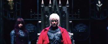 Movie still from “Casshern” (2004), directed by Kazuaki Kiriya – A man in a red jacket standing in front of a throne; Medium shot, Low angle