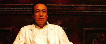 Movie still from “Casshern” (2004), directed by Kazuaki Kiriya – A man wearing glasses and a white shirt; Close Up shot, Low angle