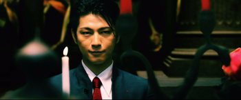 Movie still from “Casshern” (2004), directed by Kazuaki Kiriya – A man in a blue suit and a red tie; Extreme Close Up shot, Low angle