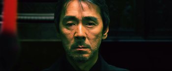 Movie still from “Casshern” (2004), directed by Kazuaki Kiriya – A person wearing a black shirt; Close Up shot, Low angle