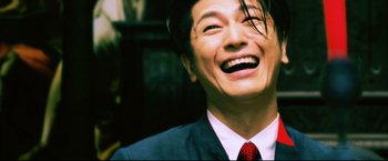 Movie still from “Casshern” (2004), directed by Kazuaki Kiriya – A person wearing a suit and tie; Close Up shot, Low angle