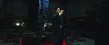 Movie still from “Casshern” (2004), directed by Kazuaki Kiriya – A man in a suit and tie holding a cigarette; Medium shot, Low angle