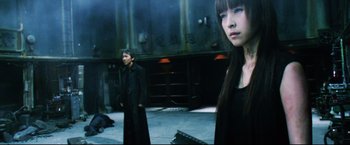 Movie still from “Casshern” (2004), directed by Kazuaki Kiriya – A man and a woman standing next to each other; Medium shot, Low angle