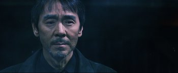 Movie still from “Casshern” (2004), directed by Kazuaki Kiriya – A person wearing a black shirt; Close Up shot, Low angle