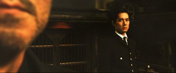 Movie still from “Casshern” (2004), directed by Kazuaki Kiriya – A man in a suit standing in front of an oven; Close Up shot, Over the shoulder angle
