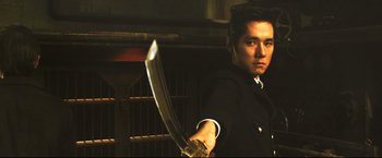 Movie still from “Casshern” (2004), directed by Kazuaki Kiriya – A man holding a sword in his hand; Close Up shot, Low angle