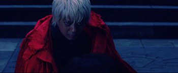 Movie still from “Casshern” (2004), directed by Kazuaki Kiriya – A woman in a red jacket looking down; Close Up shot, High angle