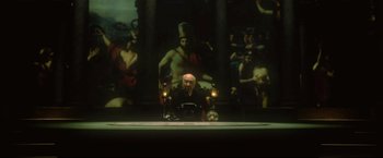 Movie still from “Casshern” (2004), directed by Kazuaki Kiriya – A man sitting in front of a painting with candles; Wide shot, High angle
