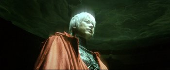 Movie still from “Casshern” (2004), directed by Kazuaki Kiriya – A statue of a man with a red cape and white hair; Close Up shot, Low angle