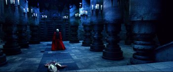 Movie still from “Casshern” (2004), directed by Kazuaki Kiriya – A man in a red robe is standing in front of candles; Extreme Wide shot, High angle