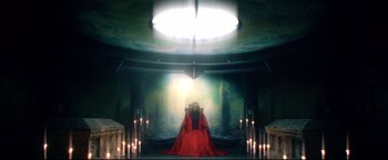 Movie still from “Casshern” (2004), directed by Kazuaki Kiriya – A woman in a red dress sitting on a stage; Wide shot, High angle