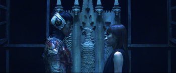 Movie still from “Casshern” (2004), directed by Kazuaki Kiriya – A man and a woman standing next to each other; Medium shot, Overhead angle
