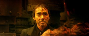 Movie still from “Casshern” (2004), directed by Kazuaki Kiriya – A person wearing a suit and tie; Close Up shot, Low angle