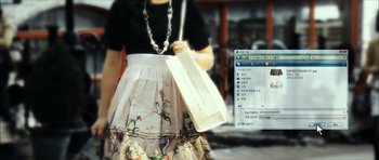 Movie still from “Castaway on the Moon” (2009), directed by Lee Hae-jun – A woman holding a paper bag in front of a computer screen; Extreme Close Up shot, High angle