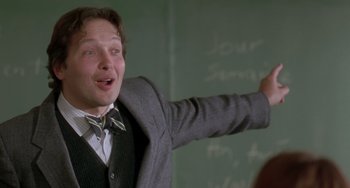 Movie still from “The Craft” (1996), directed by Andrew Fleming – A man in a suit and bow tie points at a chalkboard; Close Up shot, Low angle