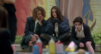 Movie still from “The Craft” (1996), directed by Andrew Fleming – A group of girls sitting on the ground; Medium shot, Low angle