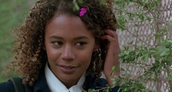 Movie still from “The Craft” (1996), directed by Andrew Fleming – A woman with a purple flower in her hair; Close Up shot, Over the shoulder angle