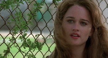 Movie still from “The Craft” (1996), directed by Andrew Fleming – A person near a chain link fence; Close Up shot, Over the shoulder angle
