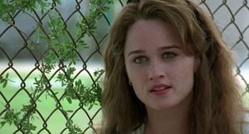 Movie still from “The Craft” (1996), directed by Andrew Fleming – A person near a chain link fence; Close Up shot, Over the shoulder angle