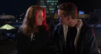 Movie still from “The Craft” (1996), directed by Andrew Fleming – A man and a woman smiling at each other; Medium shot, Over the shoulder angle