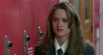 Movie still from “The Craft” (1996), directed by Andrew Fleming – A woman in a suit and tie standing in front of a red door; Close Up shot, Over the shoulder angle