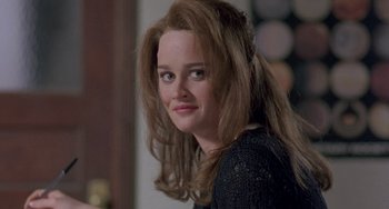 Movie still from “The Craft” (1996), directed by Andrew Fleming – A woman with long brown hair is smiling for the camera; Close Up shot, Over the shoulder angle