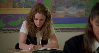 Movie still from “The Craft” (1996), directed by Andrew Fleming – A woman writing on top of an open book; Medium shot, Over the shoulder angle