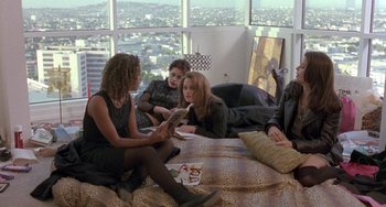 Movie still from “The Craft” (1996), directed by Andrew Fleming – A group of people sitting on a bed in front of a window; Wide shot, High angle