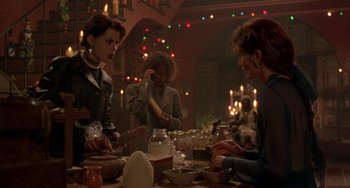 Movie still from “The Craft” (1996), directed by Andrew Fleming – A group of people sitting around a table; Medium shot, Over the shoulder angle