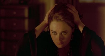 Movie still from “The Craft” (1996), directed by Andrew Fleming – A woman with her hands on her head in a dark room; Close Up shot, Over the shoulder angle