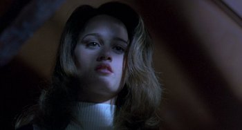 Movie still from “The Craft” (1996), directed by Andrew Fleming – A woman with long brown hair wearing a white sweater; Close Up shot, Low angle