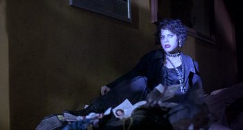 Movie still from “The Craft” (1996), directed by Andrew Fleming – A woman sitting on the floor in front of a pile of papers; Medium shot, Low angle