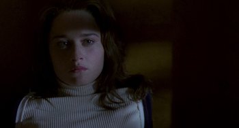 Movie still from “The Craft” (1996), directed by Andrew Fleming – A woman in a white sweater is looking at the camera; Close Up shot, Overhead angle