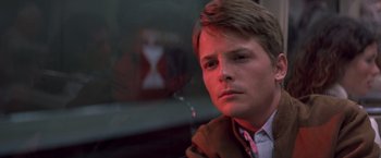 Movie still from “Casualties of War” (1989), directed by Brian De Palma – A young man sitting in front of a window looking at the camera; Close Up shot, Low angle