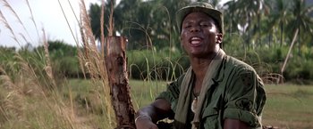Movie still from “Casualties of War” (1989), directed by Brian De Palma – A man wearing a green hat and a green shirt; Close Up shot, Low angle