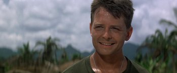 Movie still from “Casualties of War” (1989), directed by Brian De Palma – A person wearing a green shirt; Close Up shot, Low angle