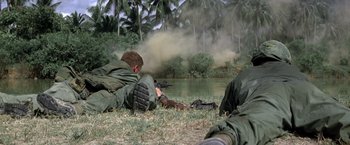 Movie still from “Casualties of War” (1989), directed by Brian De Palma – Two men in fatigues are laying in the grass; Wide shot, Low angle