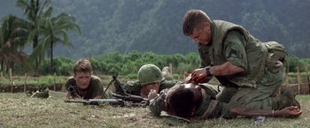 Movie still from “Casualties of War” (1989), directed by Brian De Palma – A group of men in fatigues and helmets on the ground; Medium shot, High angle